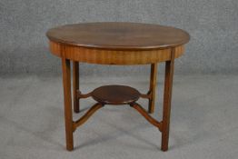 An Edwardian walnut centre table, with a circular top on square section legs joined by a circular