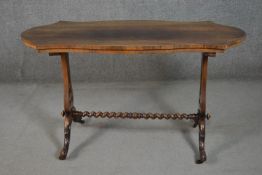 A Victorian rosewood stretcher table, with a cartouche shaped top, on pierced baluster end supports,