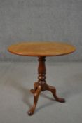 A 19th century mahogany tripod table, with an oval tilt top, on a turned stem, with tripod legs. H.