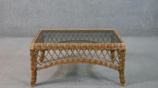 A late 20th century woven wicker coffee table, of rectangular form with a smoked plate glass top.