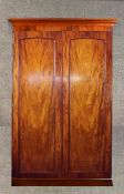 A Victorian mahogany two door wardrobe, enclosing hanging space over two short drawers and one