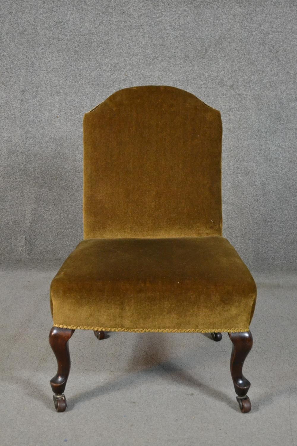 A late Victorian nursing chair, upholstered in golden velour, on mahogany cabriole legs.