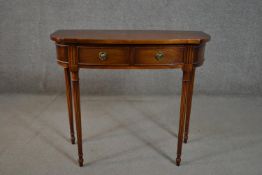 A George III style mahogany side table, with two short drawers, on turned and reeded tapering