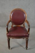 An early Victorian mahogany open armchair, the oval back, and seat upholstered in oxblood leather,