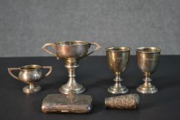 A collection of silver items, including four silver trophy cups, a cigarette case with engraved