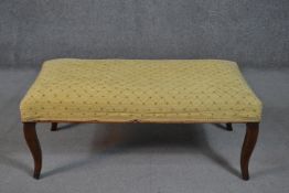 A 19th century footstool, of rectangular form with yellow upholstery, on cabriole mahogany legs. H.