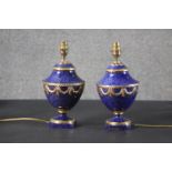 A pair of Sevres style porcelain table lamps, with a mottled cobalt blue body, decorated with gilt