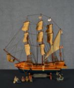 A carved and painted model of the Golden Hind, with plaque along with some figures of sailors. H.
