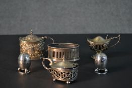 A collection of silver mustard pots and a pair of egg shaped silver salt and pepper shakers. Various