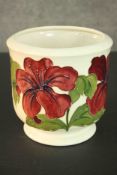 A Moorcroft pottery planter, red and yellow Hibiscus on cream ground. Signed to base. H.11 Dia.8cm.