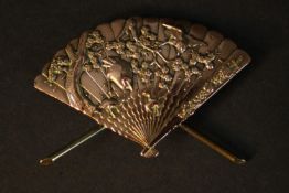 A Meiji period Shakudō ware gilt bronze miniature model of a Japanese fan with relief stork and