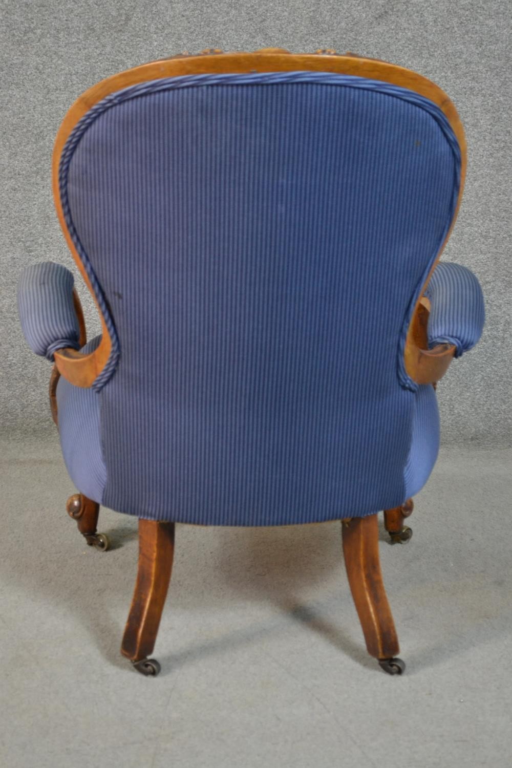 A Victorian walnut spoon back open armchair, upholstered in striped blue fabric, to the arms, seat - Image 4 of 7