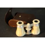 A leather cased pair of mother of pearl inlaid Leica opera glasses. L.11 W.7 D.4cm. Condition: