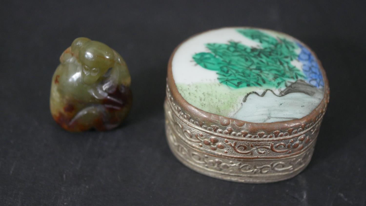 A Chinese carved jade monkey pendant along with a Chinese porcelain fragment and silver plated