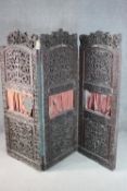 An ornately carved and pierced wood screen, possibly Burmese, of three folds, each with two panels