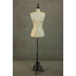 A size 12 ladies mannequin, on an adjustable stem with a scrolling back painted cast iron base.