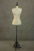 A size 12 ladies mannequin, on an adjustable stem with a scrolling back painted cast iron base.