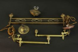 A collection of early 20th century brass wall lights, one Arts and Crafts design with a pulley