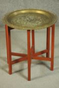 A Middle Eastern style brass tray on stand, made in Hong Kong, the circular tray engraved with