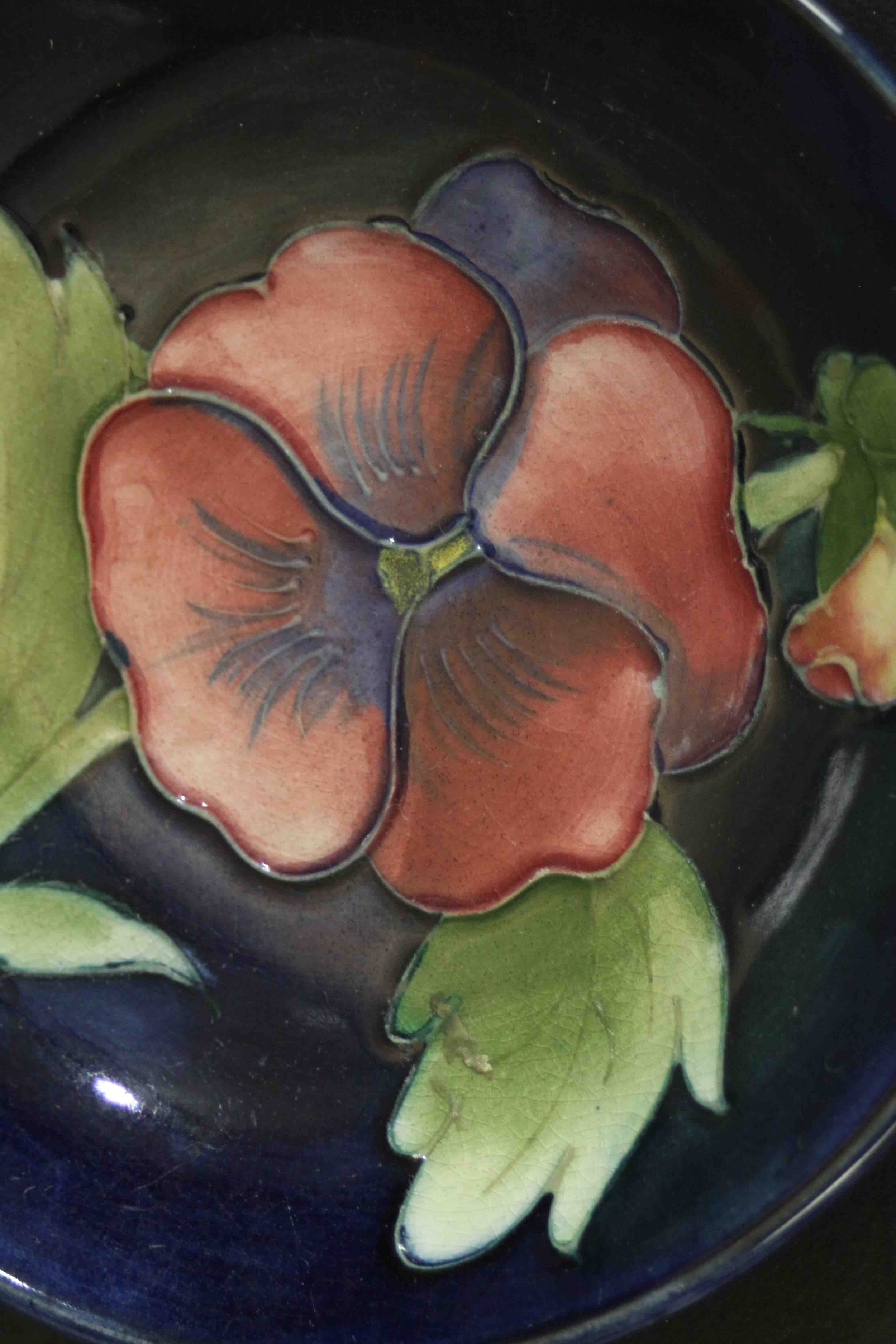 Three Moorcroft pottery dishes. Pansy and bird and fruit pattern, makers mark to the base. Dia.12cm. - Image 5 of 6
