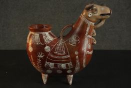 A terracotta Peruvian folk art jug in the form of a bull with hand painted white glaze design. H.