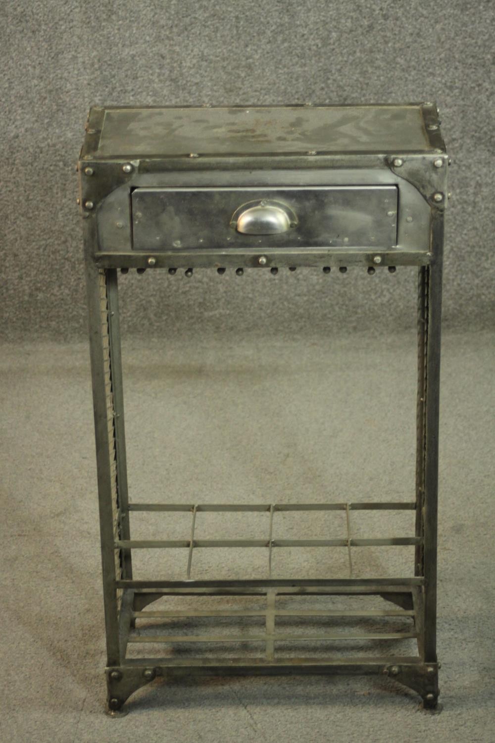 An industrial steel cabinet, with a single drawer over a divider, the sides with a lattice mesh,