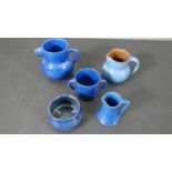 A collection of five pieces of blue glaze C H Branham Barum art pottery, one jug with a fish