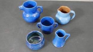 A collection of five pieces of blue glaze C H Branham Barum art pottery, one jug with a fish