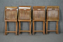 A set of four Gloster teak folding garden chairs, with slatted back and seat, with a loose