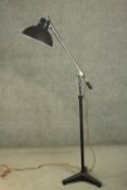 A mid 20th century adjustable floor standing reading lamp, with a black painted shade, on a