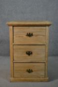 A late Victorian pine pedestal chest, of four drawers with brass swing handles, on a plinth base.