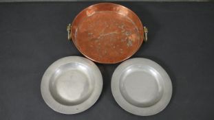 Two 18th century pewter plates with impressed makers mark along with a twin handled Victorian copper