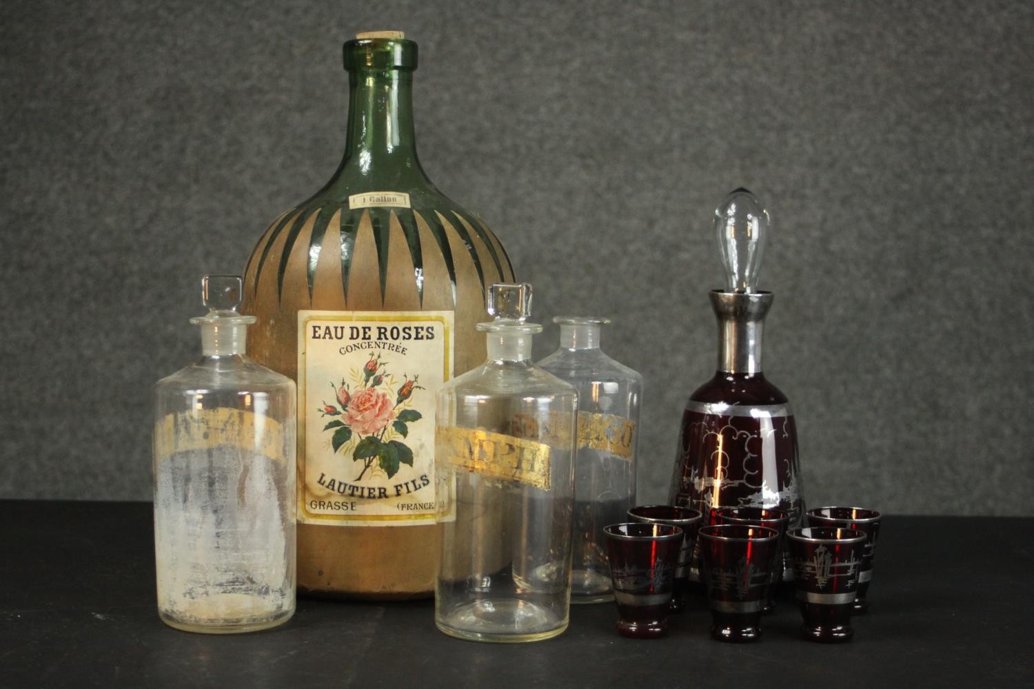 A collection of glass including a large rose water green glass demijohn, a Venetian silvered ruby