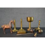 A collection of metal ware including a brass goblet, a pair of early 20th century candlesticks, a