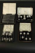 A collection of cased silver, including a set of six silver coffee spoons, a set of six acrylic