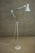 A grey painted Herbert Terry style Anglepoise standard lamp, on a tubular stem with a circular base.