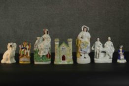 A collection of seven 19th century Staffordshire pottery figures, including a castle form spill