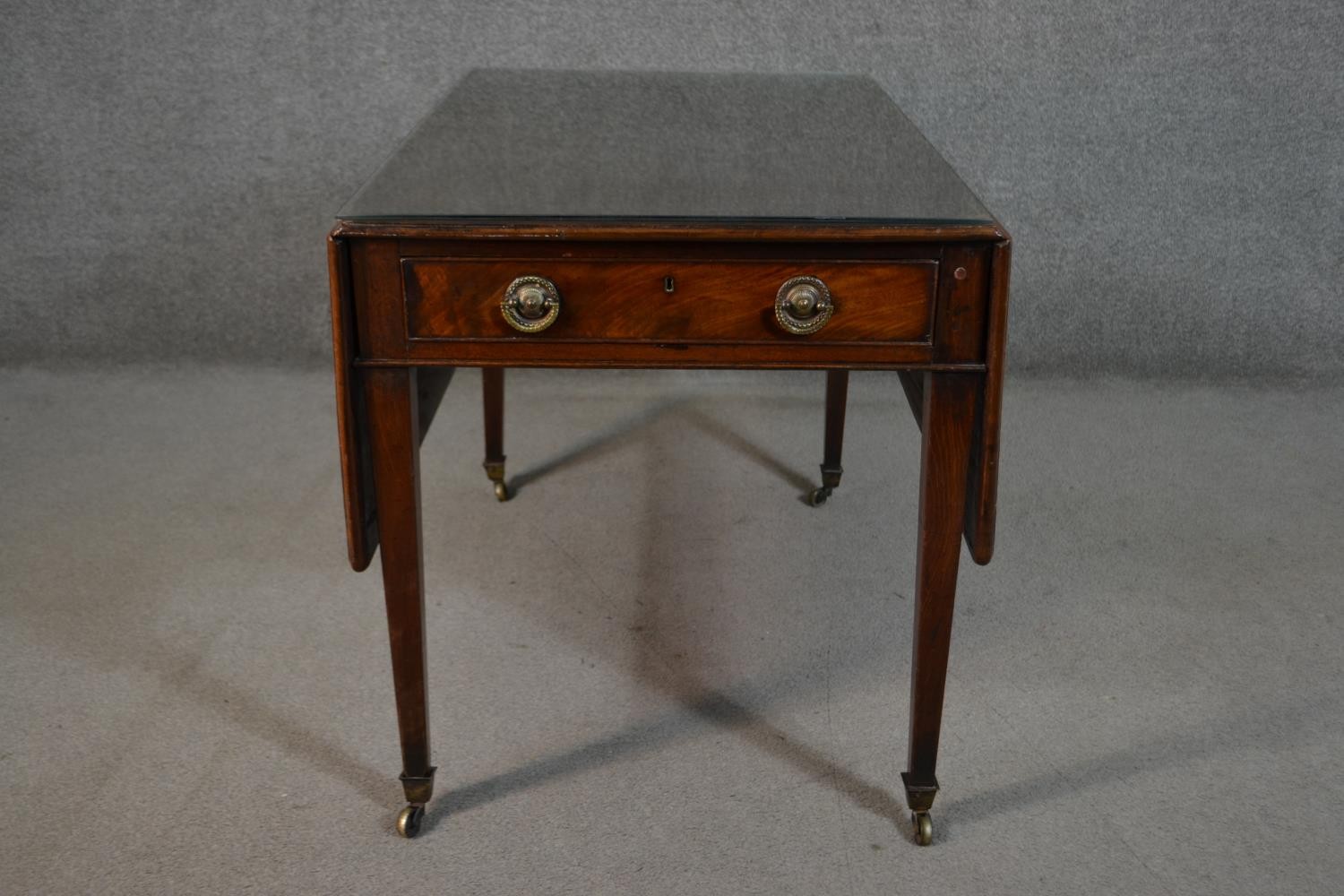 A 19th century mahogany Pembroke table, the top with drop leaves and a moulded edge, over two end