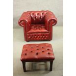 A red leather Chesterfield armchair, buttoned to the back, arms, seat, and front, on bun feet,