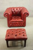 A red leather Chesterfield armchair, buttoned to the back, arms, seat, and front, on bun feet,