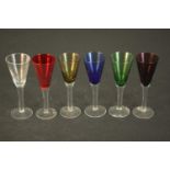 A set of six multi coloured glass wine glasses with clear stems. H.15 Dia.5cm.