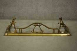 A 19th Century Art Nouveau brass fire fender with sloped edge with typical Art Nouveau scroll work