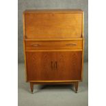 A circa 1960s teak bureau, the fall front opening to reveal a fitted interior, over a single drawer,