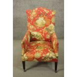 A circa 1900 hump back armchair, upholstered in a Chinoiserie fabric on a salmon ground, on mahogany