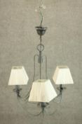 A late 20th century wrought verdigris metal three branch chandelier, with ivory coloured pleated