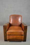 A circa 1930s design tan leather club armchair, with angular fruitwood arms, and studded borders, on