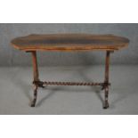 A Victorian rosewood stretcher table, with a cartouche shaped top, on pierced baluster end supports,