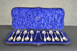 A set of twelve Victorian silver shell design tea spoons and sugar tongs in a fitted leather case.