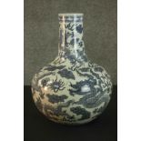 A 20th century Chinese ceramic blue and white hand painted dragon and cloud design bottle vase.