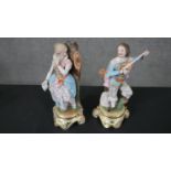 Two hand painted porcelain figures on scrolling design stands, one of a gentleman playing a lute and